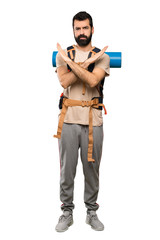 Hiker man making NO gesture over isolated white background