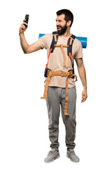Hiker man making a selfie over isolated white background