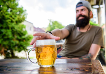 He has the bad habit of drinking too much beer. Chilled beer mug on table. Bearded man drinking...