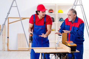 Two professional contractors laying flooring at home