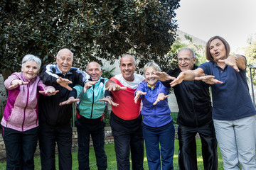 Gruppo di anziani signori vestiti in tuta si gode la vita al parco