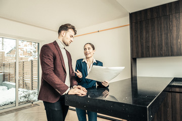 Businessman and realtor standing in the kitchen of his future house