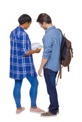 Back view of a multinational couple of students who are looking into a notebook.