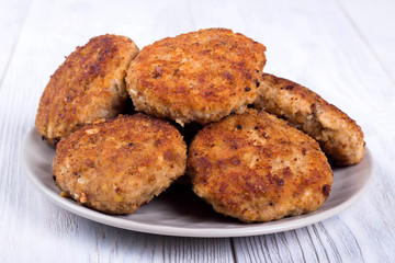 cutlets on a grey plate, on a white wooden background