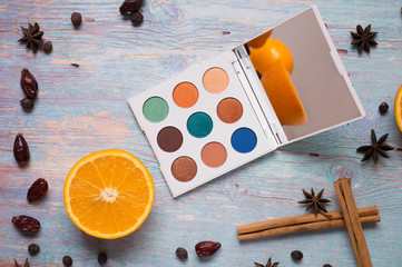 fashion summer eye palettes with  fruit and spices at blue wooden background. close up