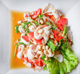 Spicy salad seafood with squid shrimp and peanut vegetable lettuce salad served on plate