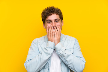 Blonde man over isolated yellow wall with surprise facial expression