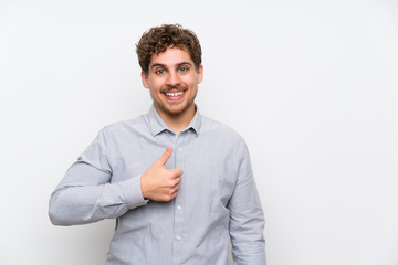 Blonde man over isolated white wall giving a thumbs up gesture