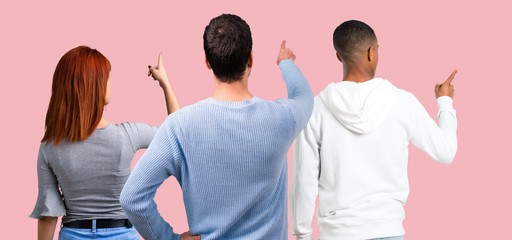 Group of three friends pointing back with the index finger