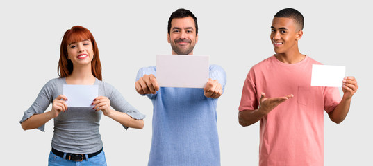 Group of three friends holding an empty white placard for insert a concept