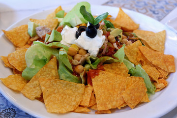 Crunchy Mexican Salad with Nacho Chips, Avocado, Chickpeas, Olives and Sour Cream