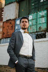 A man in a gray suit poses on the street to advertise men's clothing. Shooting for men's clothing store