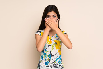 Teenager girl with floral dress covering mouth with hands