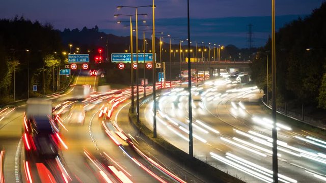 Car lights at rush hour on an motorway junction, traffic on London Orbital motorway M25, timelapse.