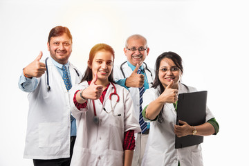 Group of successful Indian medical doctors, male and female standing isolated with thumbs up sign...