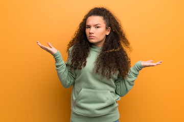 Teenager girl over ocher wall unhappy for not understand something