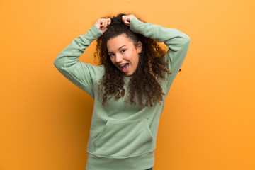 Happy Teenager girl over ocher wall.