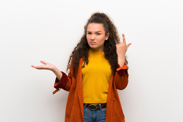 Teenager girl with coat making the gesture of madness putting finger on the head