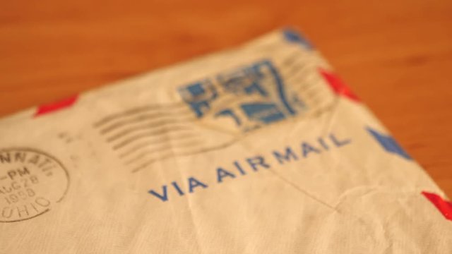 Vintage stamp and the words 'Via Airmail' on paper letter. Slider zoom out.