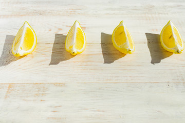 close up of quarter lemons on wooden table. Hard shadows in a saunny day