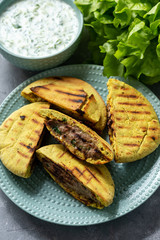 Meat stuffed pita bread and tzatziki dip.