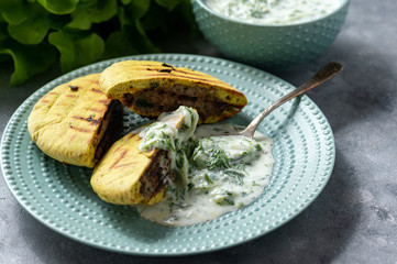 Meat stuffed pita bread and tzatziki dip.