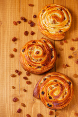 Fresh homemade pain au raisins croissant  over wooden background