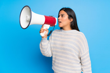 Young Colombian girl with sweater shouting through a megaphone