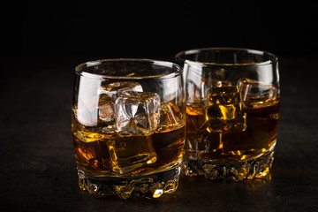 Whiskey in the glasses on black.