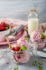 Strawberry ice cream with mint in a glass. Light background