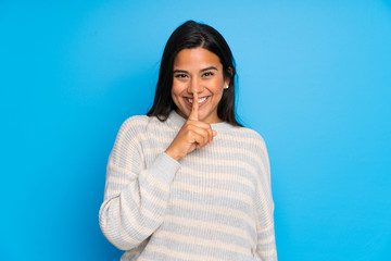 Young Colombian girl with sweater doing silence gesture