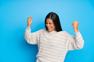 Young Colombian girl with sweater celebrating a victory