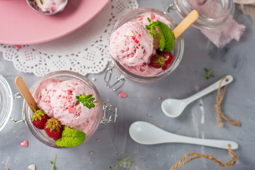 Strawberry ice cream with mint in a glass. Light background