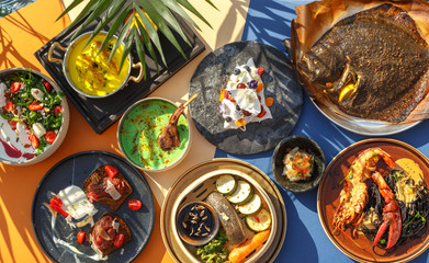 set of various culinary dishes and plates of different shapes and colors on a colored background. Sunlight. Top view.