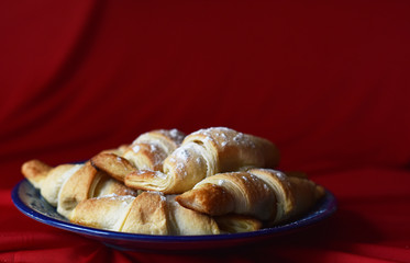 croissants on a blue dish on a red background