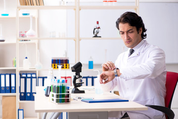 Young handsome chemist working in the lab