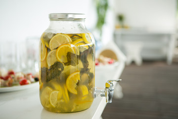 Glass bank of lemonade with sliced citrus fruits