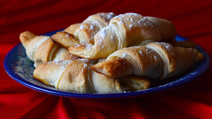 croissants on a blue dish on a red background