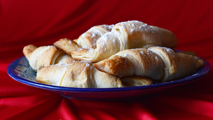 croissants on a blue dish on a red background