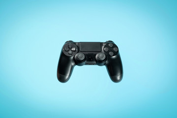 Photo of modern gamepad against light blue colorful background