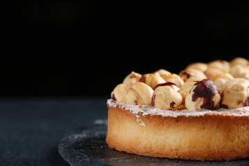 tart with nuts and honey on dark background