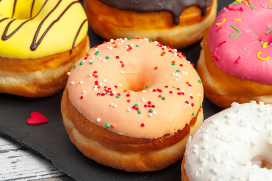 Glazed colored donuts background image. Macro shot