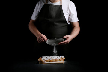 man in apron serving strudel. recipe of strudel or pie. baker decorating concept