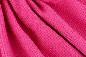 Pink corrugated cotton textile - close up of fabric texture. Cotton Fabric Texture. Pink Clothing Background. Text Space. Abstract background and texture for designers.