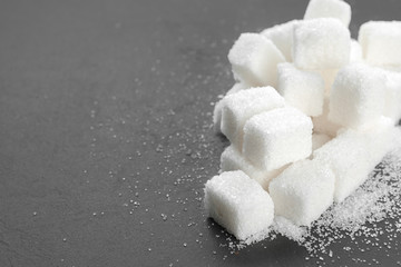 White sugar cubes over black background close up