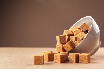 Brown cane sugar cubes on a light brown background