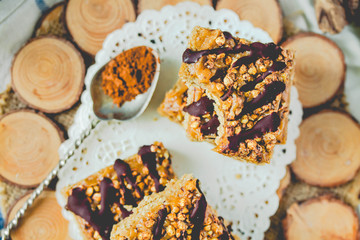 Granola bar cake with date caramel and chocolate. Healthy sweet dessert snack. Cereal granola bar with nuts, fruit and berries on a wooden. Top view. Toning.