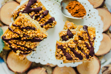 Granola bar cake with date caramel and chocolate. Healthy sweet dessert snack. Cereal granola bar with nuts, fruit and berries on a wooden. Top view.