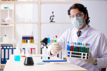 Young handsome chemist working in the lab