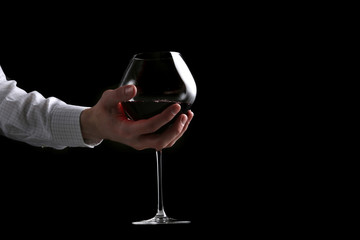 Fototapeta na wymiar mans hand hold wine glass isolated on black background